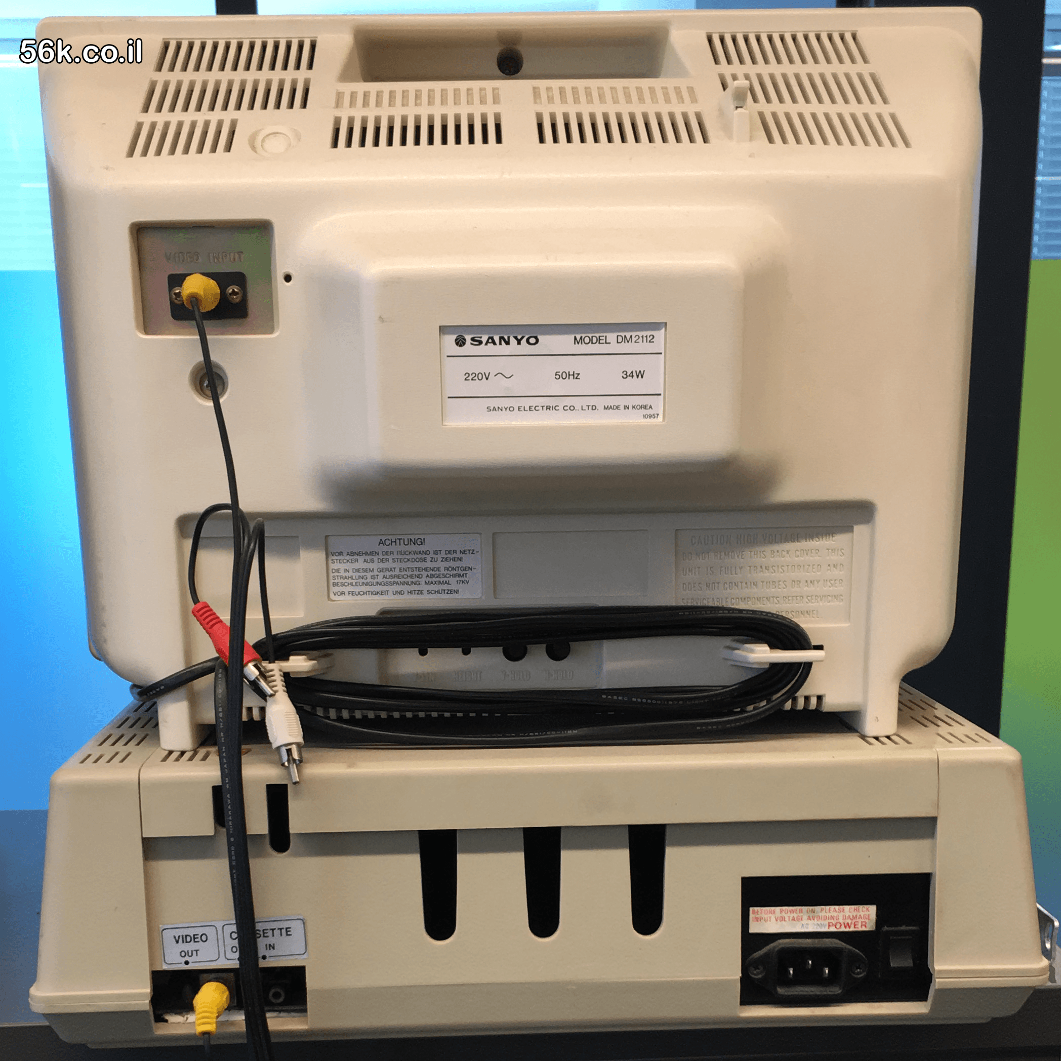 הפאנל האחורי של מוניטור Sanyo DM2112 ומחשב תואם Apple II מדגם Spring 208, המציג את יציאת הווידאו, חיבורי הטייפ ושקע החשמל
